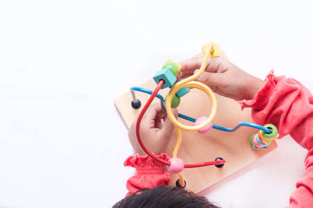 Kid's hands playing with different shapes of blocks and moving it around its track.