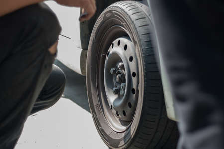 Selangor, Malaysia - June 28, 2018: A mechanic is changing the car wheel at tyre shop in Kajang,...