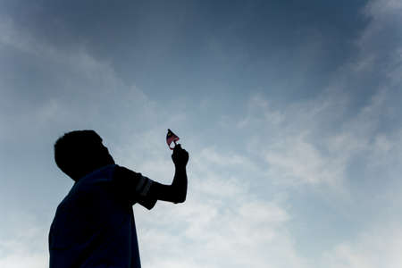 Independence Day concept. A happy and proud citizen holding and waving Malaysian flag. sky...
