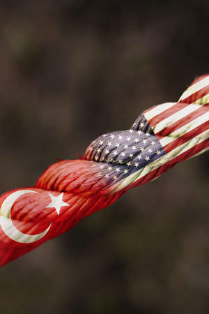 Country flags of Republic of Turkey and United States of America in a rope shape. Concept of foreign or diplomatic relations between countries.の写真素材
