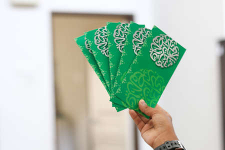 Money packet as Hari Raya gift for Ramadan and Eid al-Fitri Celebration. "Salam Aidilfitri" text in Arabic and Malay translated in English as "Eid al-Fitr"の写真素材