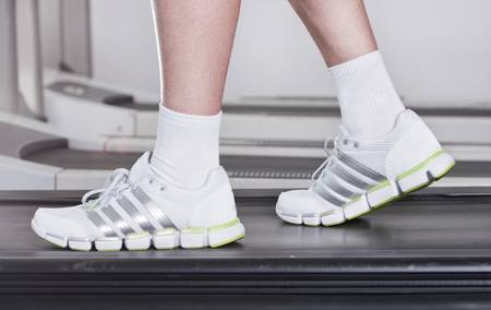 feet of the guy in sneakers on a racetrack in fitness club