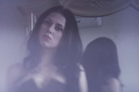 Beautiful brunette thinks the bedroomの写真素材