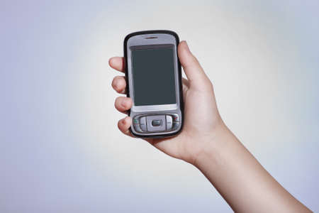 Cell phone with touchscreen in female hand on gray backgroundの写真素材