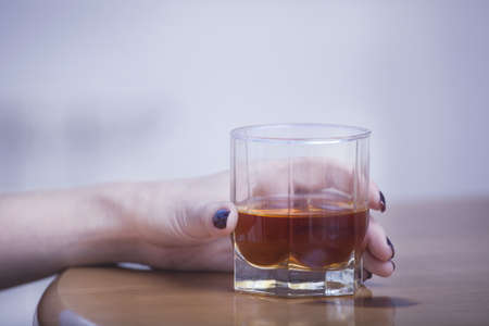 glass of scotch whiskey in handの写真素材