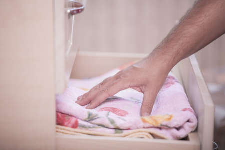 hand takes the towel out of the closetの写真素材