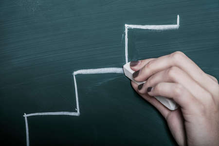 human hand drawing career ladder with chalk on a boardの写真素材