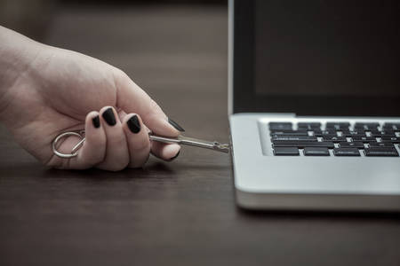 hand sticks the flash drive in the laptopの写真素材