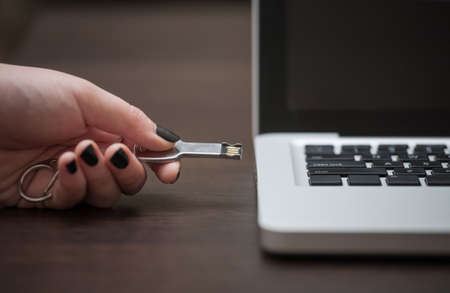 Hand pushing USB stick into laptopの写真素材