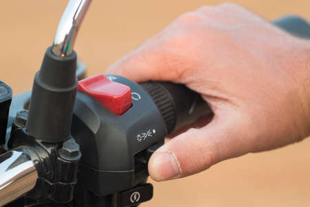 The hand holds a wheel of a motorcycle