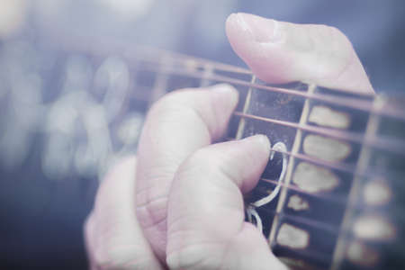 the hand holding, the neck of the guitar