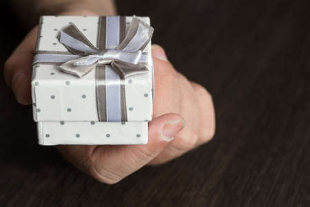 Hand with small present on a tableの写真素材