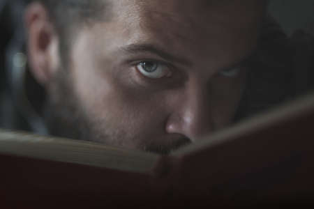 Man's eyes peeking out of the book