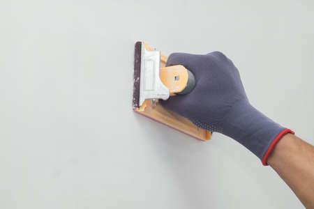 hand grinding wall with sandpaperの写真素材