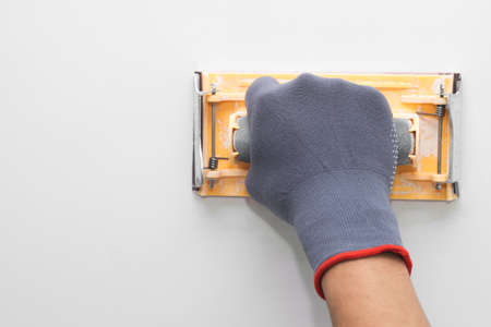 hand grinding wall with sandpaperの写真素材