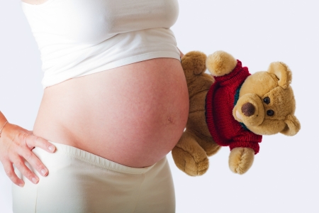 Pregnant woman from the profile with a teddy bearの写真素材