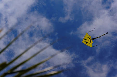 A yellow kite in a blue sky 