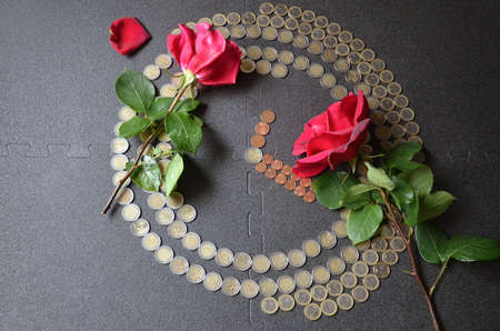 two red roses and clock from the European Union coins on a gray backgroundの写真素材