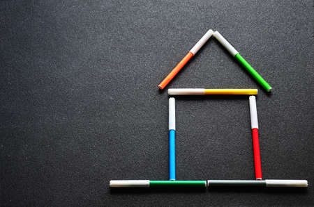 stylized house out of colored felt-tip pens on a dark backgroundの写真素材