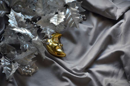 silver Christmas tree branch on a satin gray background and the Christmas Toy Crescent