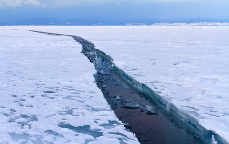 Open cracked ice on lake Baikal at Cape Khoboy Olkhon island. Photo toned.の写真素材