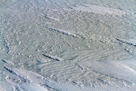 Tight inflatable snow on the ice of lake Baikal. Bizarre small islets, dunes and waves. Photo toned.の写真素材