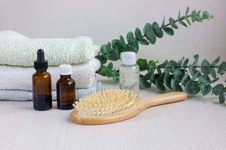 Composition with hair care products, towel and brush on wooden tableの写真素材
