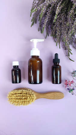 Composition with medication bottles, hairbrush and herb heather on purple background. Flat lay, Space for text.の写真素材
