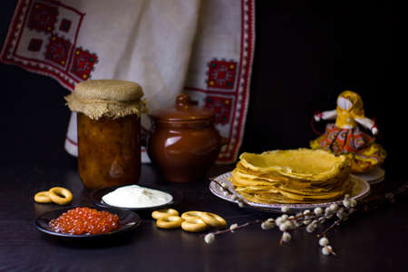 Traditional Russian food and symbols on dark background for Maslenitsa festival. Pancakes, caviar,...