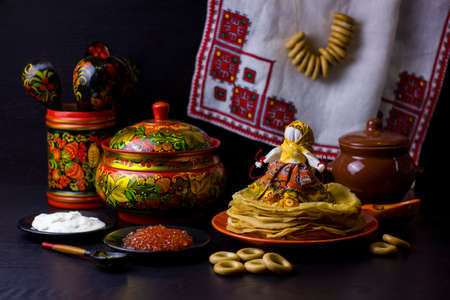 Traditional Russian food and symbols on dark background for Maslenitsa festival. Pancakes, caviar,...