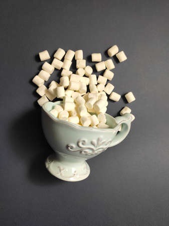 Vintage cup with marshmallows on black background.