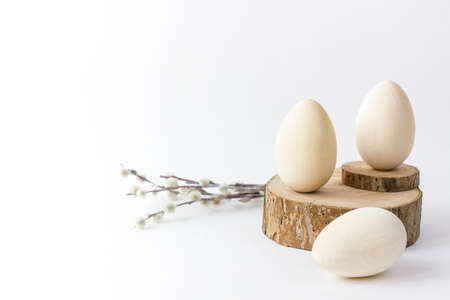 Wooden eggs on saw cut of a tree with pussy willow. Easter Basckground with space for text. Focus picked.の写真素材