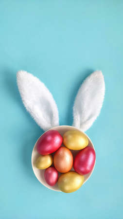 Easter creative background with Easter eggs and bunny ears. Top view with copy space.