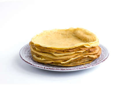 Thin pancakes stacked on a plate isolated on white background.の写真素材