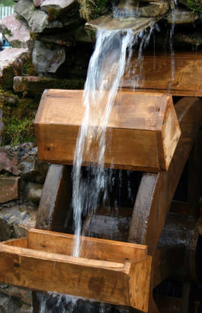 The water stream falls on a water-mill ladleの写真素材