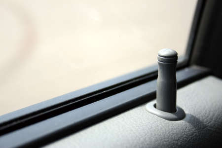 Fragment of an automobile door - the button, the panel and glass. Shallow depth of field. Focus on the button.の写真素材