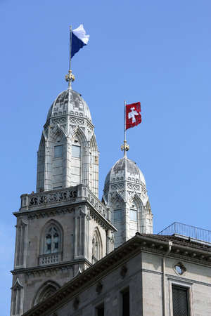 National flag and canton flag on towers of Grossmunster Cathedral - major landmarks of Zurich cityscape Switzerlandの写真素材