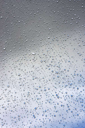 Water drops on glass against the sky