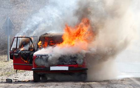Burning car on desert rural roadの写真素材