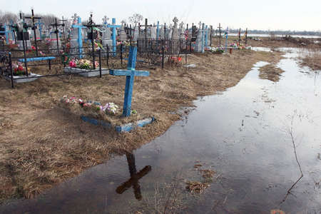 Flooded rural cemetery graves and display the cross in the waterの写真素材