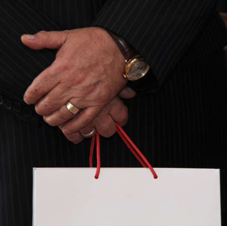 Closeup of male hand holding paper bag with handles