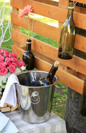 A restaurant table on a park with bottle of wine in bucketの写真素材