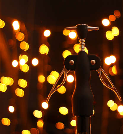 Corkscrew and bottle of wine on the background bokehの写真素材