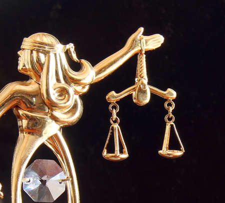 Themis statue and handcuffs over dark background