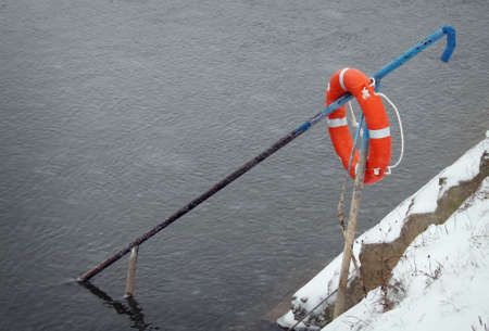 Orange lifebuoy  Cloudy winter day  Equipment for rescue of people  Service for life saving の写真素材