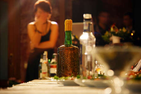 Bottle of moonshine plugged corn on table in restaurantの写真素材