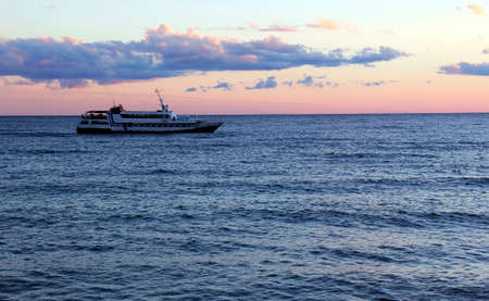 Boat sailing on sea at sunsetの写真素材