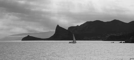 Dramatic sunset at the sea with sailboat