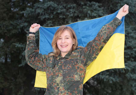 LUTSK, UKRAINE - JANUARY 10: Girl in military uniform with ukrainian flag in Lutsk, Ukraine on January 10, 2015のeditorial素材