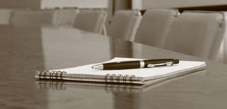 Closeup of notepad on table in empty conference room before business meetingの写真素材